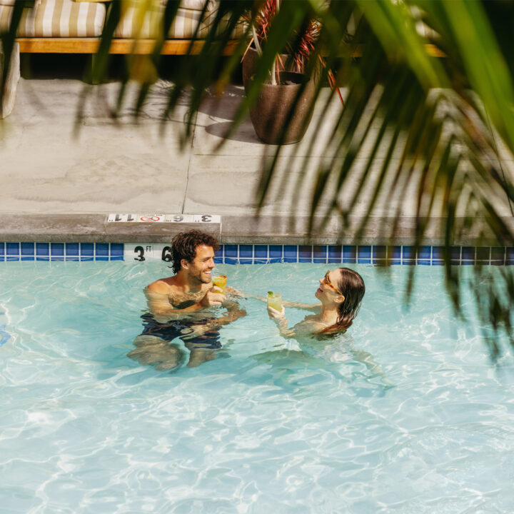 Poolside guests sipping caravan swim club cocktails